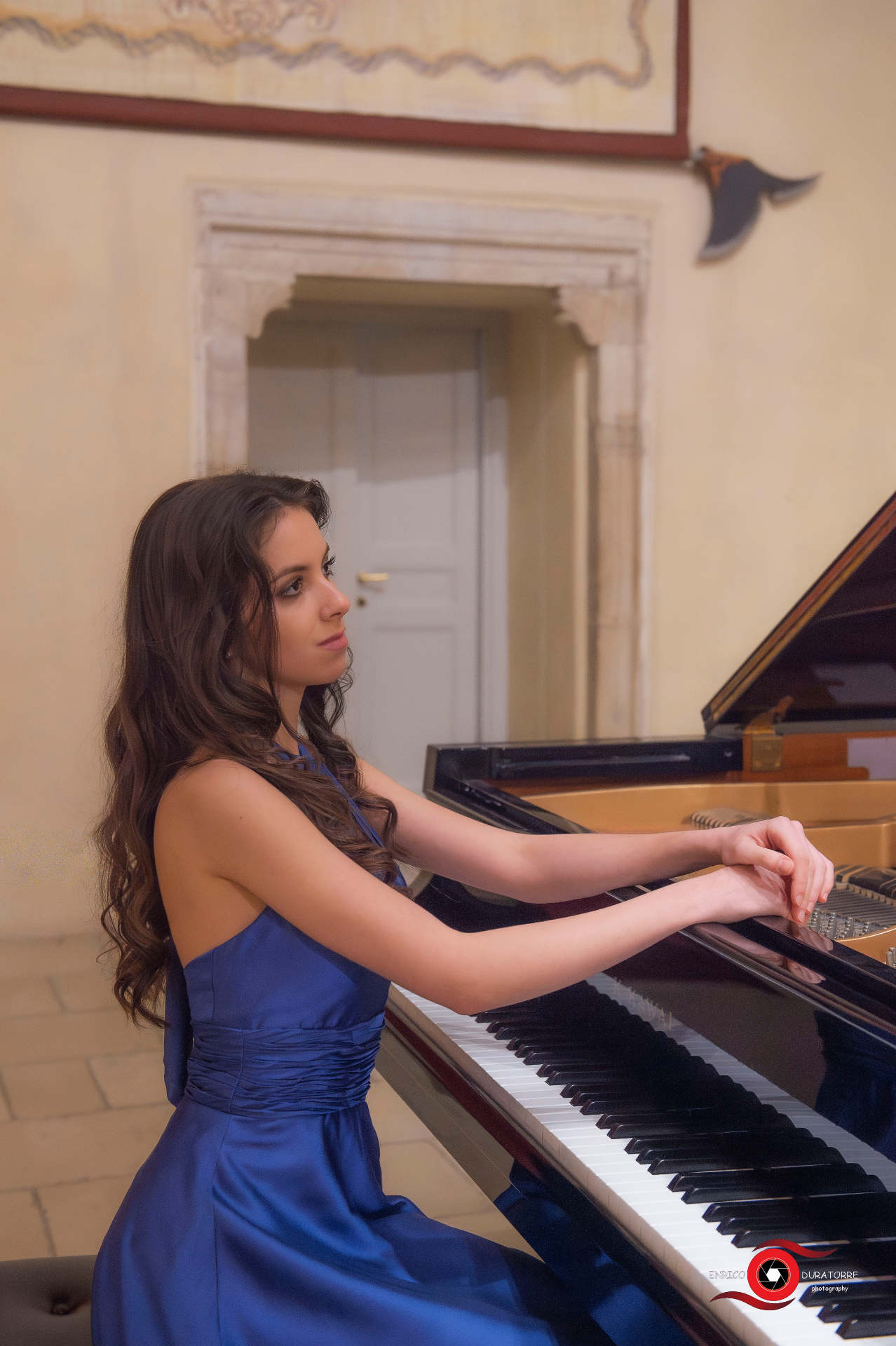 Henrietta in a blue gown at the grand piano